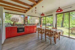 a kitchen with red cabinets and a table with chairs at La Barraço in Nalzen +15 photos