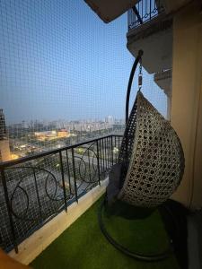 a hammock on a balcony with a view of a city at THE COZY STAY STUDio in Greater Noida +1 photo