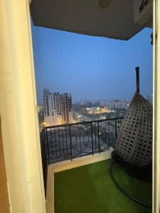 a balcony with a hammock and a view of a city at THE COZY STAY STUDio in Greater Noida