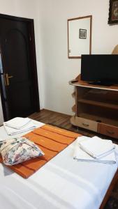 a room with a bed and a dresser at Pensiunea Iris in Săcele