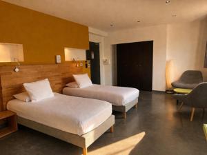 ein Hotelzimmer mit zwei Betten und einem Stuhl in der Unterkunft H85 in Chatte + 31 Fotos