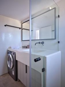 a bathroom with a sink and a washing machine at Mouragio Stay - Aliki , Paros in Aliki
