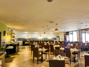 a dining room with tables and chairs and a restaurant at Accra City Hotel in Accra