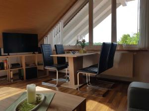 a living room with a table and chairs and a tv at Ferienwohnung Hahn, 95129 in Rhauderfehn