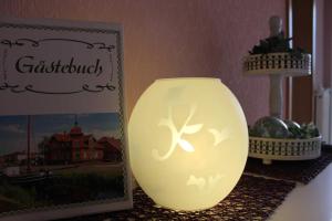a yellow vase sitting on a table next to a picture at Ferienwohnung Hahn, 95129 in Rhauderfehn