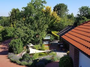 a garden next to a house with a roof at Ferienwohnung Hahn, 95129 in Rhauderfehn