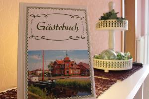 a picture frame on a shelf with a picture of a house at Ferienwohnung Hahn, 95129 in Rhauderfehn +21 photos