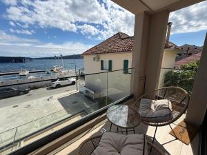 a balcony with a table and chairs and a view of the water at Zenith Lux Apartment Beachfront & Parking in Bijela