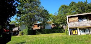 a house on a grassy hill next to a building at Berg-Bungalows Leinleitertal in Heiligenstadt