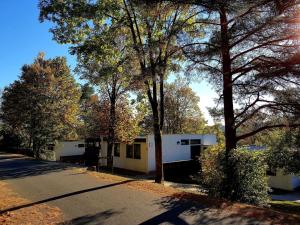 a white house with trees in front of a street at Berg-Bungalows Leinleitertal in Heiligenstadt