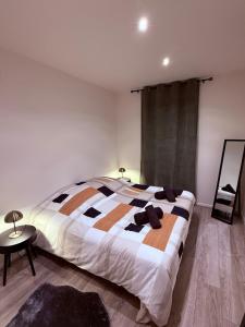 a bedroom with a bed and a table and a mirror at T3 spacieux - Centre et Technhom in Belfort