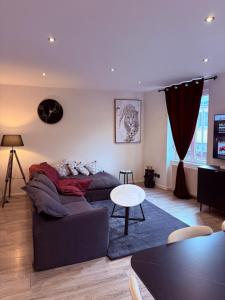 a living room with a couch and a table at T3 spacieux - Centre et Technhom in Belfort