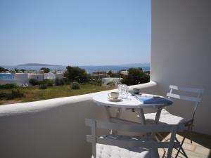 a table and chairs on a balcony with a view at Mouragio Stay - Aliki , Paros in Aliki