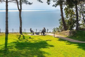 two people sitting on a bench looking at the water at Appartement "Opal" mit Penthouseflair - Oase am Haff in Garz