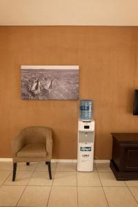 a room with a chair and a water cooler at Apartments @ 125 in Gaborone