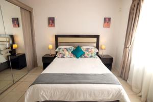 a bedroom with a large bed with two night stands at Apartments @ 125 in Gaborone +29 photos