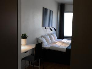 a bedroom with a bed and a desk with a window at Hotel Torslanda in Torslanda