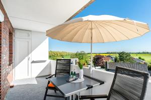 a patio with a table and an umbrella at Apartment Korthals 41 in Wangerland