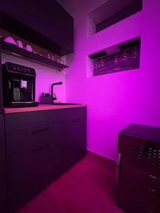 a pink kitchen with a sink and a microwave at Romantic Spa del Lago in Viverone