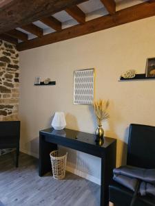 a black desk in a room with two chairs at Le relai de la tannerie in Lanvallay