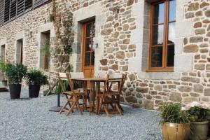 a table and chairs in front of a building at Le relai de la tannerie in Lanvallay