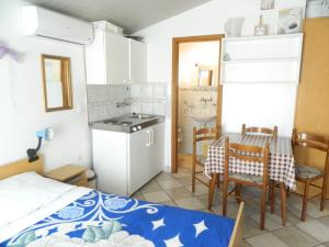 a room with a bed and a kitchen and a table at Apartment Jakoubek in Rogoznica