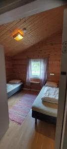 a bedroom with two beds in a wooden cabin at timber cabin Eresfjord med båt til leie in Øverås