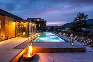 a swimming pool with a fire next to a building at PAPA RHEIN - Hotel & Spa in Bingen am Rhein