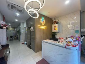 a restaurant with a counter and a chandelier at HPY Hotel in Ipoh