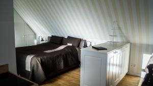 a bedroom with a bed and a white dresser at Hotel Haus Broichtal in Alsdorf