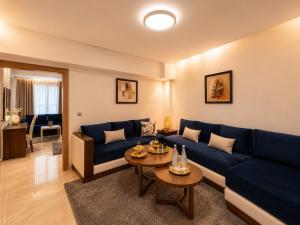 a living room with a blue couch and a table at Appart-hotel Marrakech Inn in Marrakesh