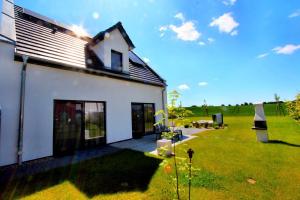 a white house with a large yard next to it at Villa Anima in Göhren-Lebbin