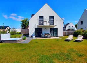 a white house with a patio and a yard at Villa Anima in Göhren-Lebbin