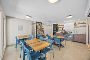 a restaurant with wooden tables and blue chairs at Ocean Breeze in San Juan