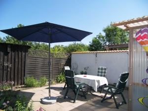 a table and chairs with an umbrella on a patio at Reethaus Natalie in Korswandt