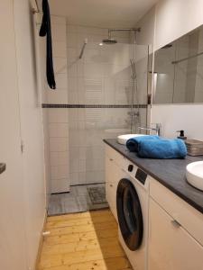 a bathroom with a sink and a washing machine at Avec CLIMATISEUR appartement DESIGN vous propose, un appartement 2 chambres et salon, 3 appartements une pièce, NETFLIX, lits faits à votre arrivée, serviettes de toilette, Ménage, Wifi ,Plage à 190m, BOX à Vélos, paiement 3 fois sans frais in Dieppe