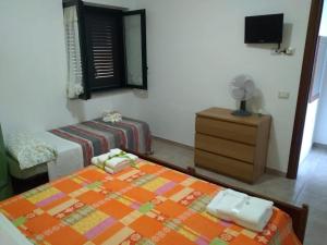a bedroom with a bed and a dresser and a fan at B&B Josefine in Marina di Camerota