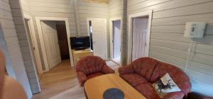 a living room with a couch and chairs and a tv at timber cabin Eresfjord med båt til leie in Øverås