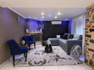 a living room with a couch and blue chairs at Giorgos Suite - Jacuzzi Hideaway in Lydia, Kavala in Lidia