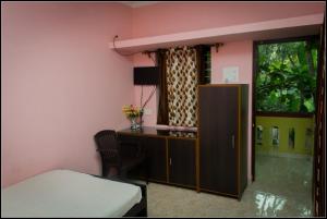 a bedroom with a bed and a cabinet and a window at All Seasons Guest House in Vasco Da Gama