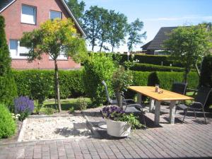 a patio with a wooden table and chairs in a garden at Birgits Huuske in Stedesdorf