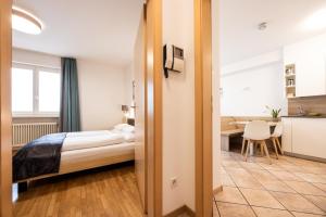a bedroom with a bed and a desk in a room at Pixner Apartments in Bolzano