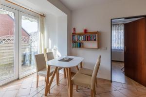 a dining room with a table and chairs and a window at Haus Windböe, Wohnung 3 in Duhnen