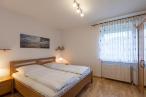 a bedroom with a bed and a large window at Haus Windböe, Wohnung 3 in Duhnen