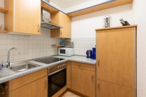 a small kitchen with wooden cabinets and a sink at Haus Windböe, Wohnung 3 in Duhnen