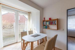 a dining room with a table and chairs and a window at Haus Windböe, Wohnung 3 in Duhnen