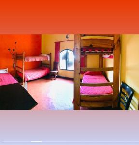a room with three bunk beds with pink sheets at Cafayate Backpackers in Cafayate