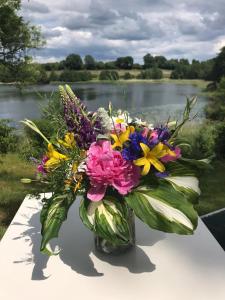 a vase of flowers sitting on a table near a lake at Ferienhaeuser Poenitz am See in Klingberg