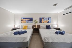 two beds in a room with blue pillows on them at Ocean Breeze in San Juan +119 photos
