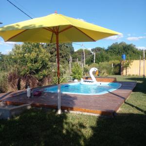 a yellow umbrella and a swan in a pool at Casa Quinta Doña María in Concepción del Uruguay